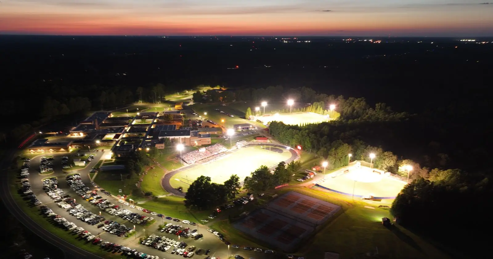 Aerial view of Southern Alamance High School lit up for a Friday night football game at dusk